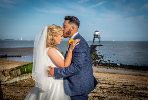 Bride and Groom celebrate with a kiss on the beach