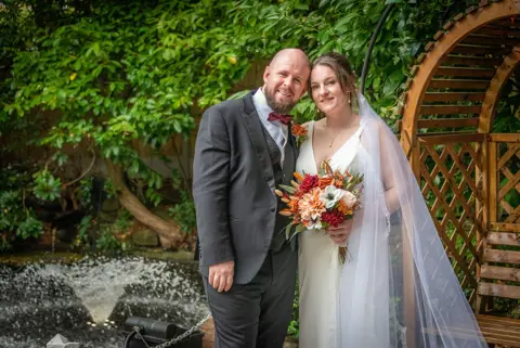 Relaxed post-wedding couples photo in the venue garden