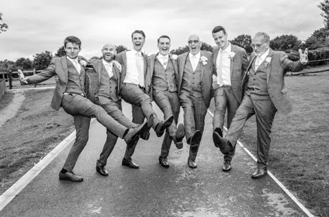 A groom celebrates with his groomsman on his wedding day.