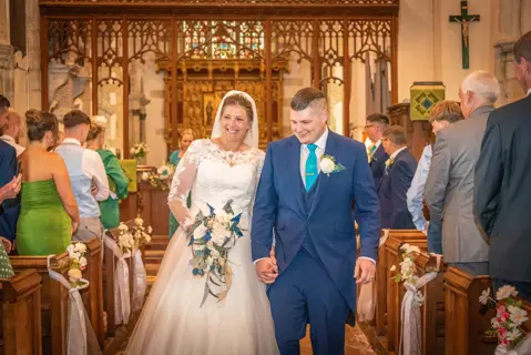 The bridge and groom walk down the aisle together after their church marriage