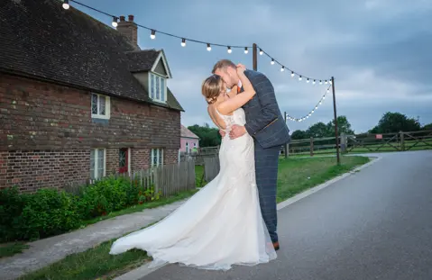 The Bride and Groom embrace under the lights at Kent Life