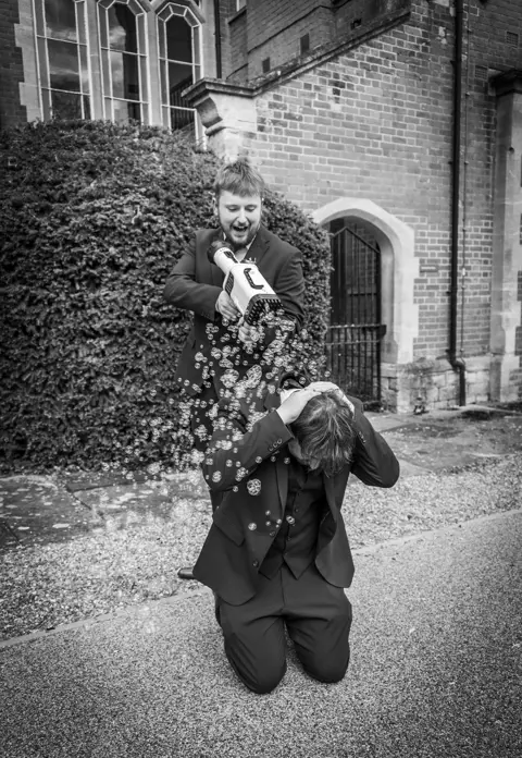 Groomsman have fun with a bubble machine at the wedding reception