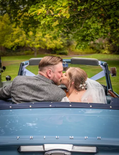 The Bride and Groom in their classic Triumph wedding car