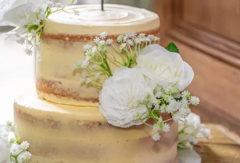 Wedding cake with floral decorations photographed at The Vines, Rochester