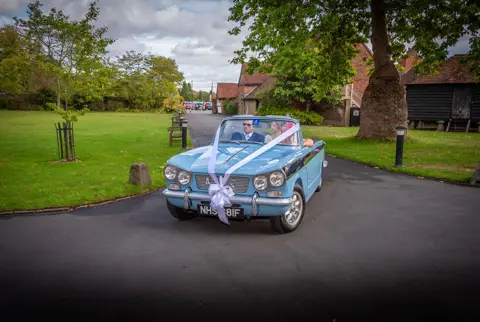 The bride arrives at the ceremony in a class wedding car