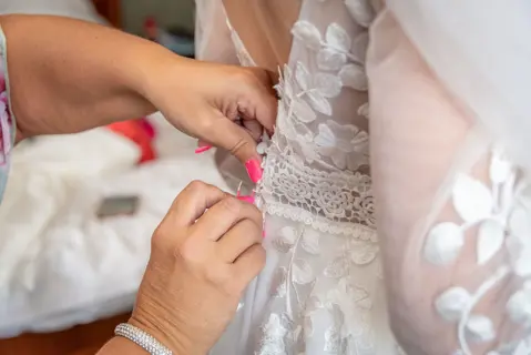 The bride is buttoned into her Wedding Dress