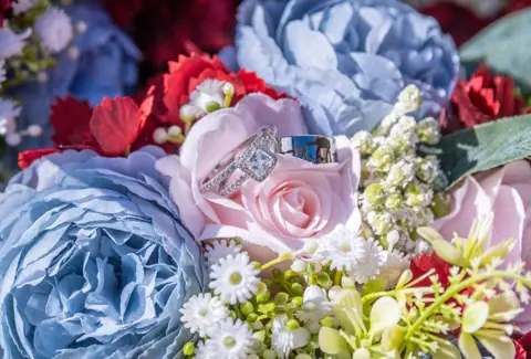 Wedding rings nestled in a colourful wedding bouquet